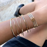 Just the perfect touch of Smart Chic + Minimalist.  The spiral accented bangle is a timeless style that transcends season and elevates your stacking game with other bracelets.       14k gold-filled